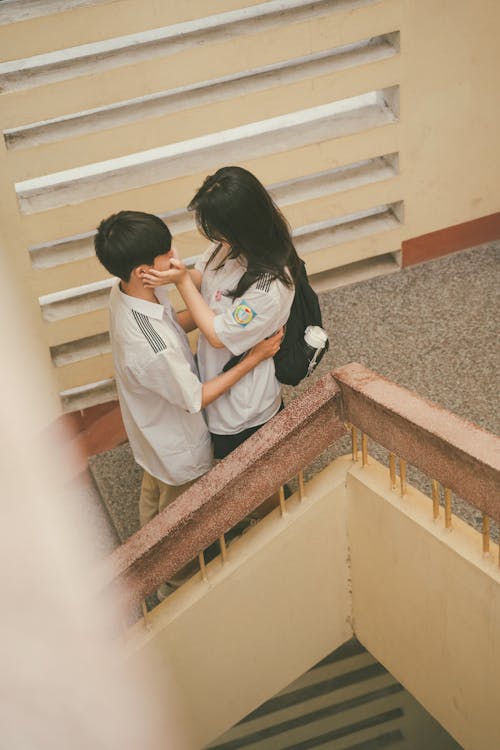 Girl and Boy Embracing on Stairs