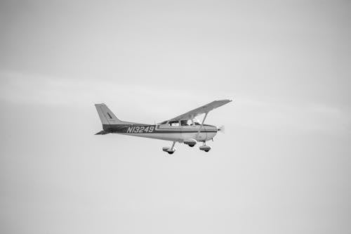 Black and White Photo of a Small Airplane Flying