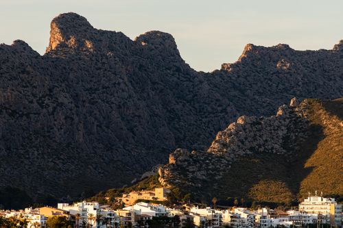 Free Scenic view of rocky hills and a town in Palma, Spain at sunset. Stock Photo