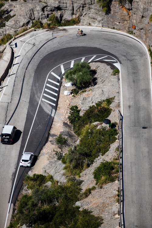 Cars and Cyclist on Road in Mountains