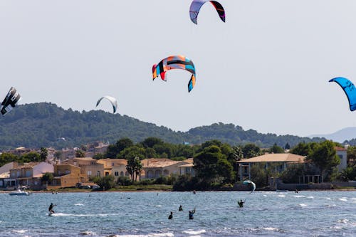 People Kitesurfing on Sea Shore
