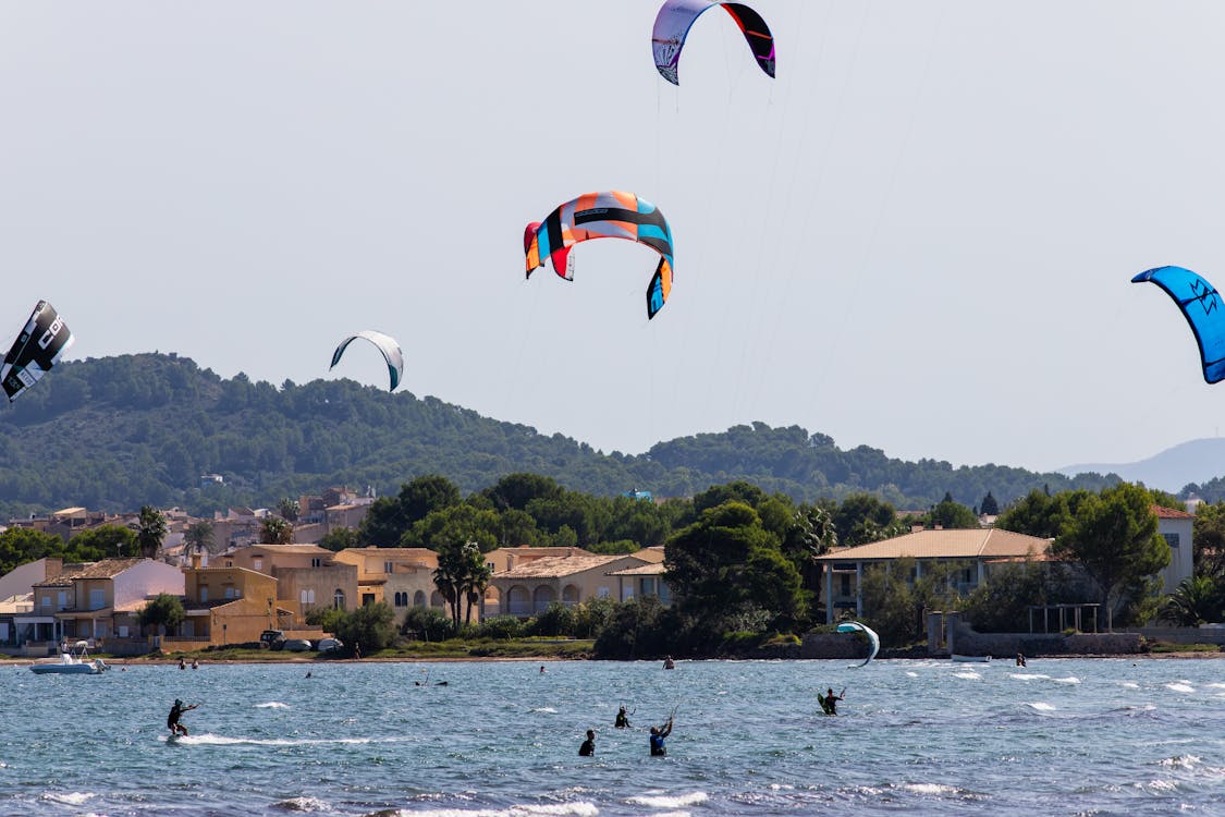People Kitesurfing on Sea Shore