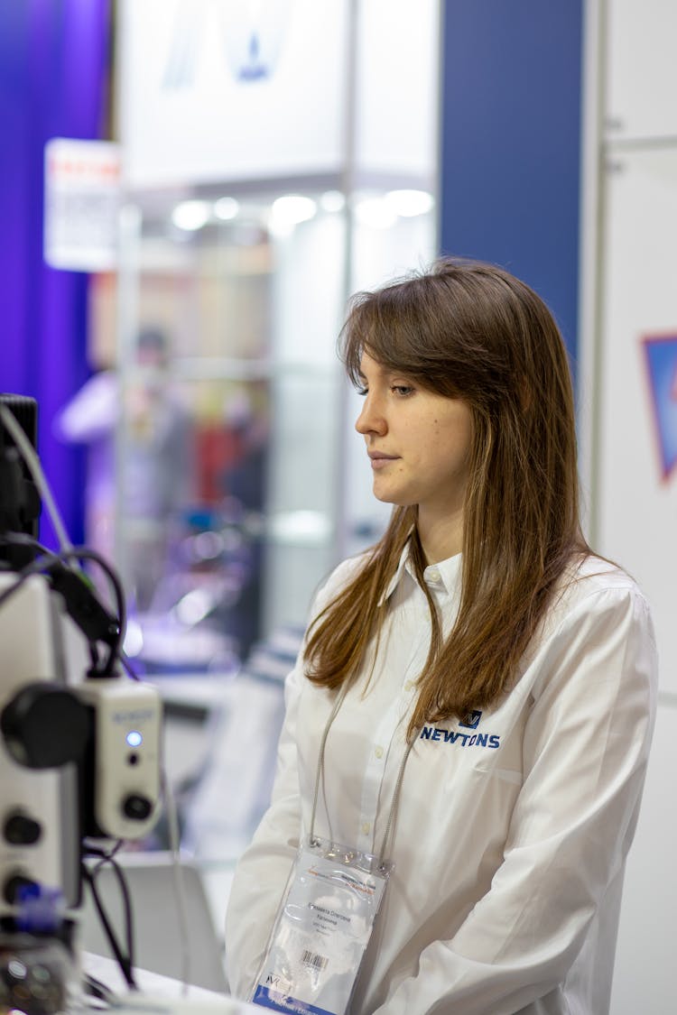 Woman With Brown Hair Standing In Employee Uniform