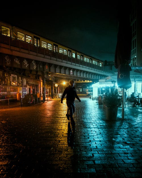 Pedestrian in City Illuminated at Night