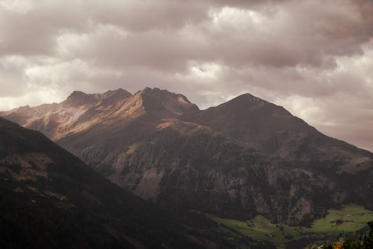 A breathtaking view of rugged mountains under a moody sky at twilight.