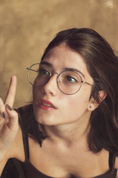 一位戴眼镜的年轻女子若有所思地向上看的特写肖像