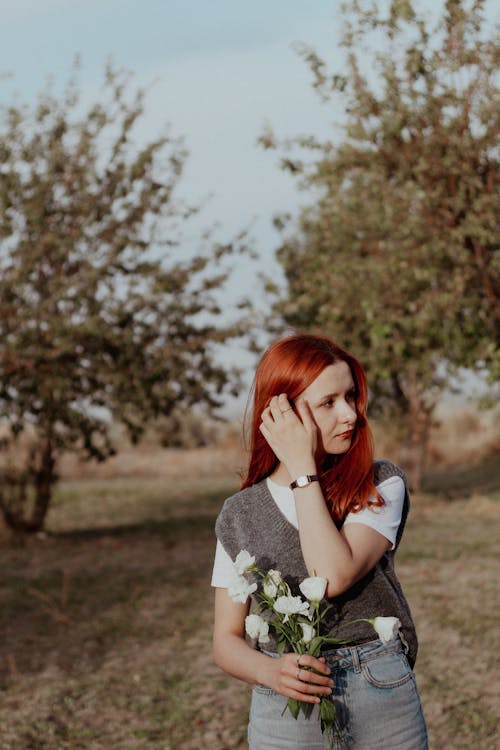 Redhead Woman Standing with Flowers