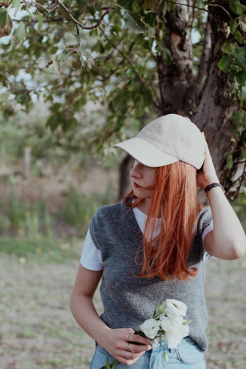 Redhead Woman in Cap and with Flowers
