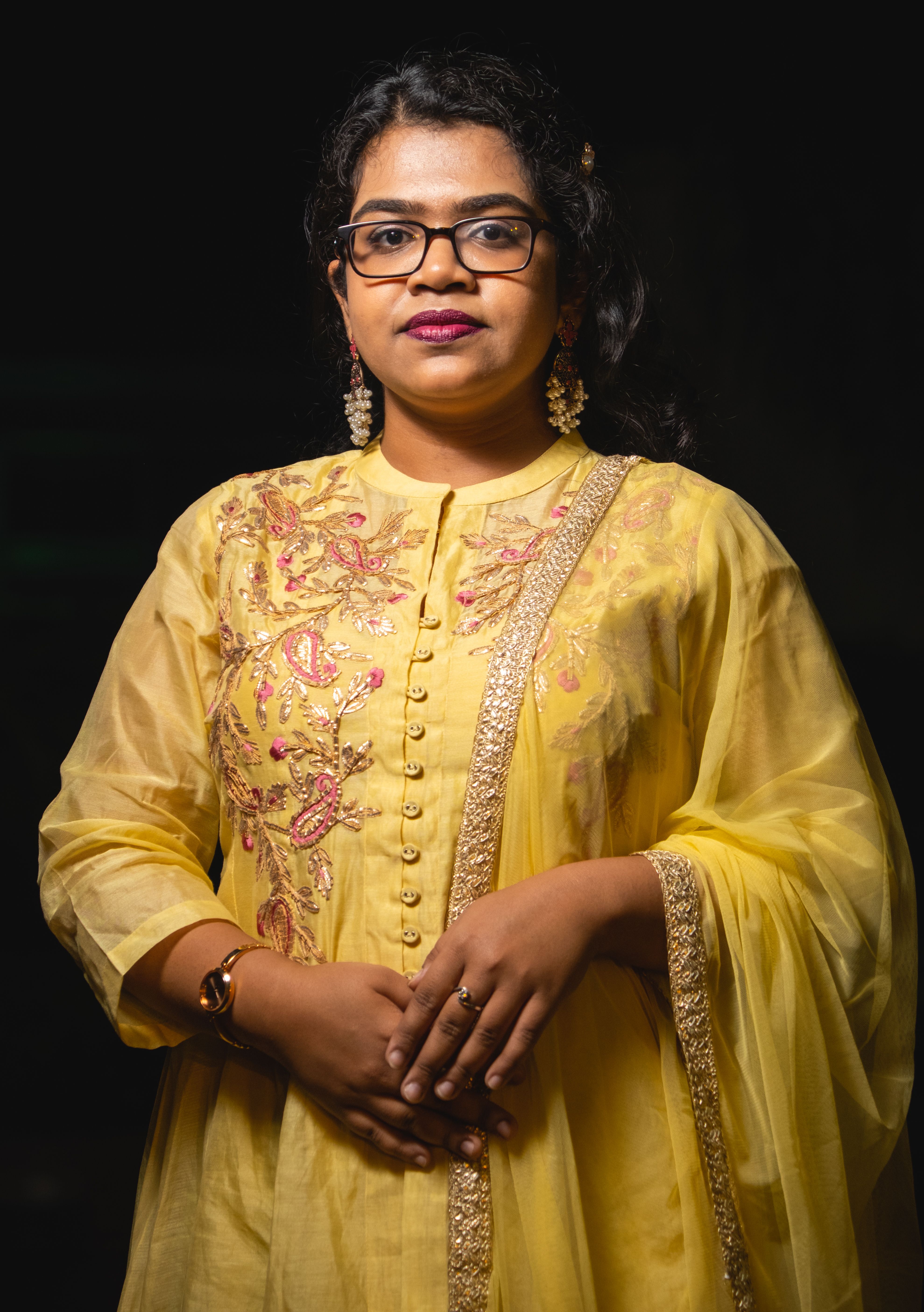 Portrait of a young woman in an embroidered yellow gown, showcasing traditional elegance.