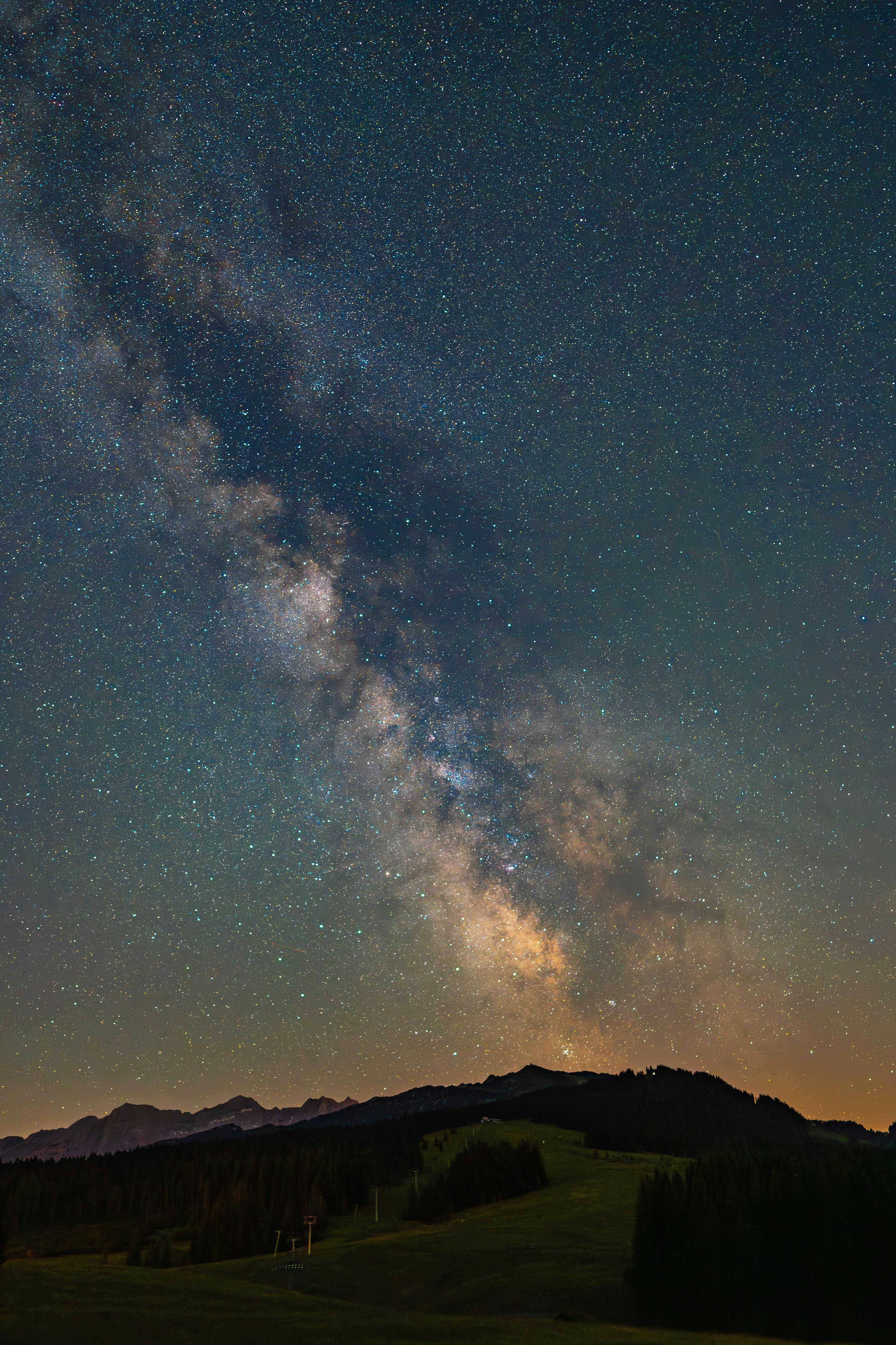 A breathtaking view of the Milky Way stretching across a clear night sky over a rural hillside.