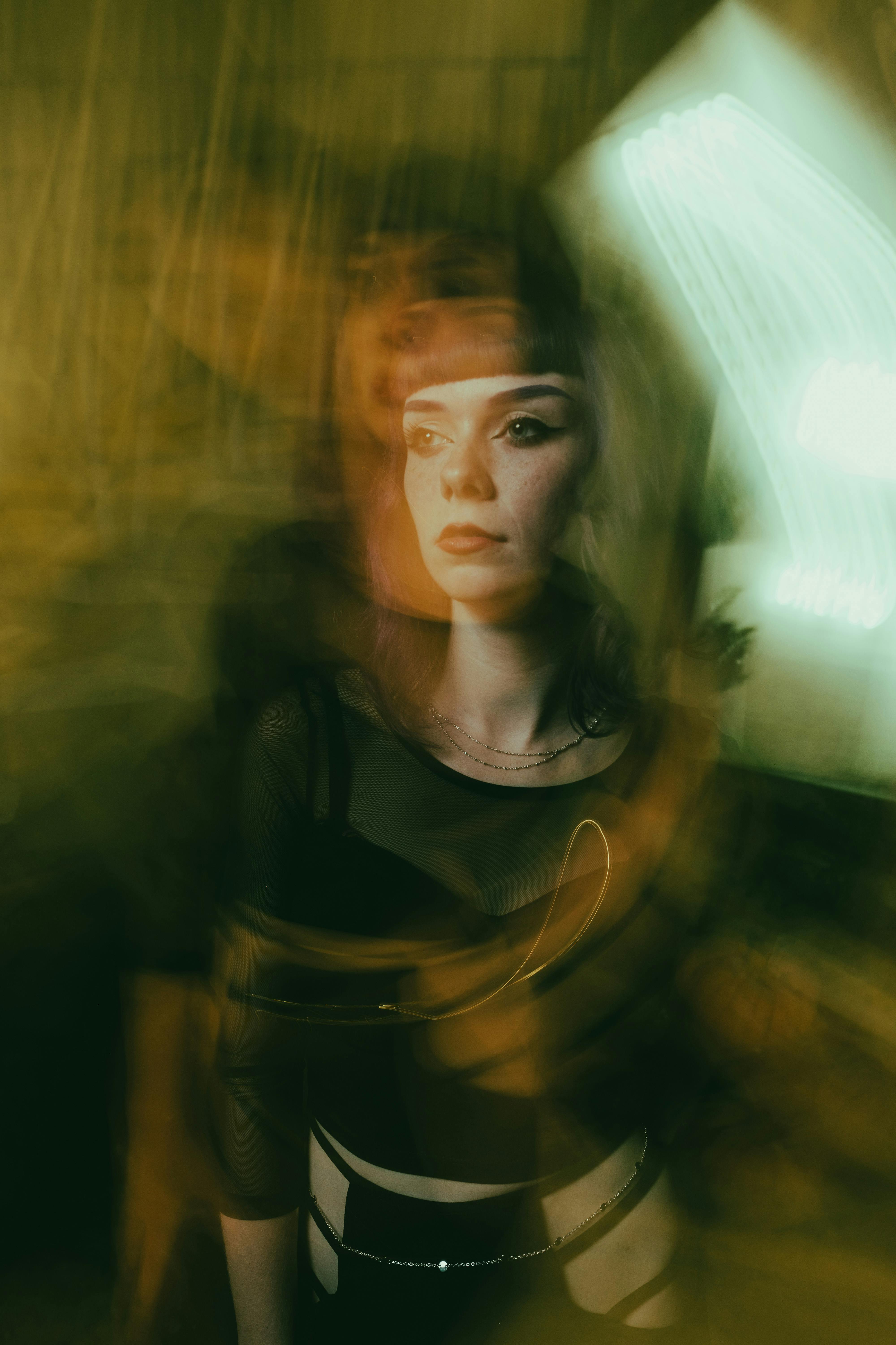 Dynamic portrait capturing a woman with a unique motion blur effect, creating an artistic and moody atmosphere.