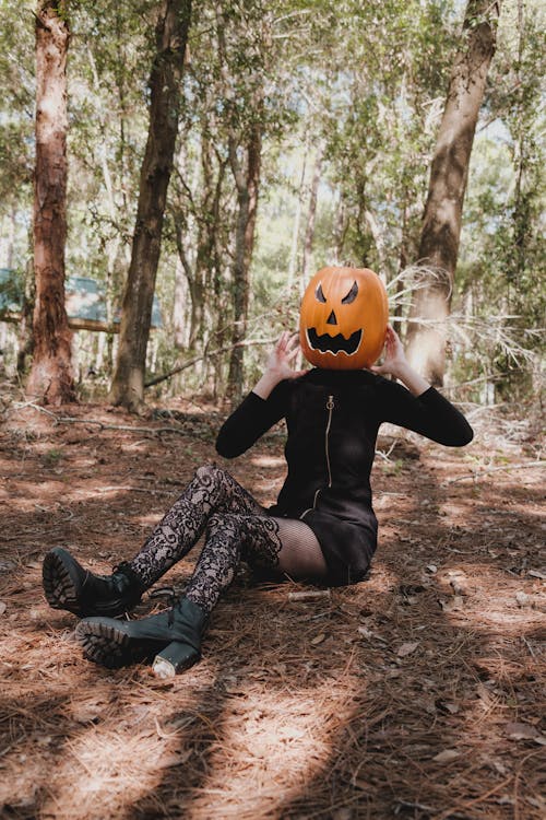 Woman with Pumpkin on Head in Forest