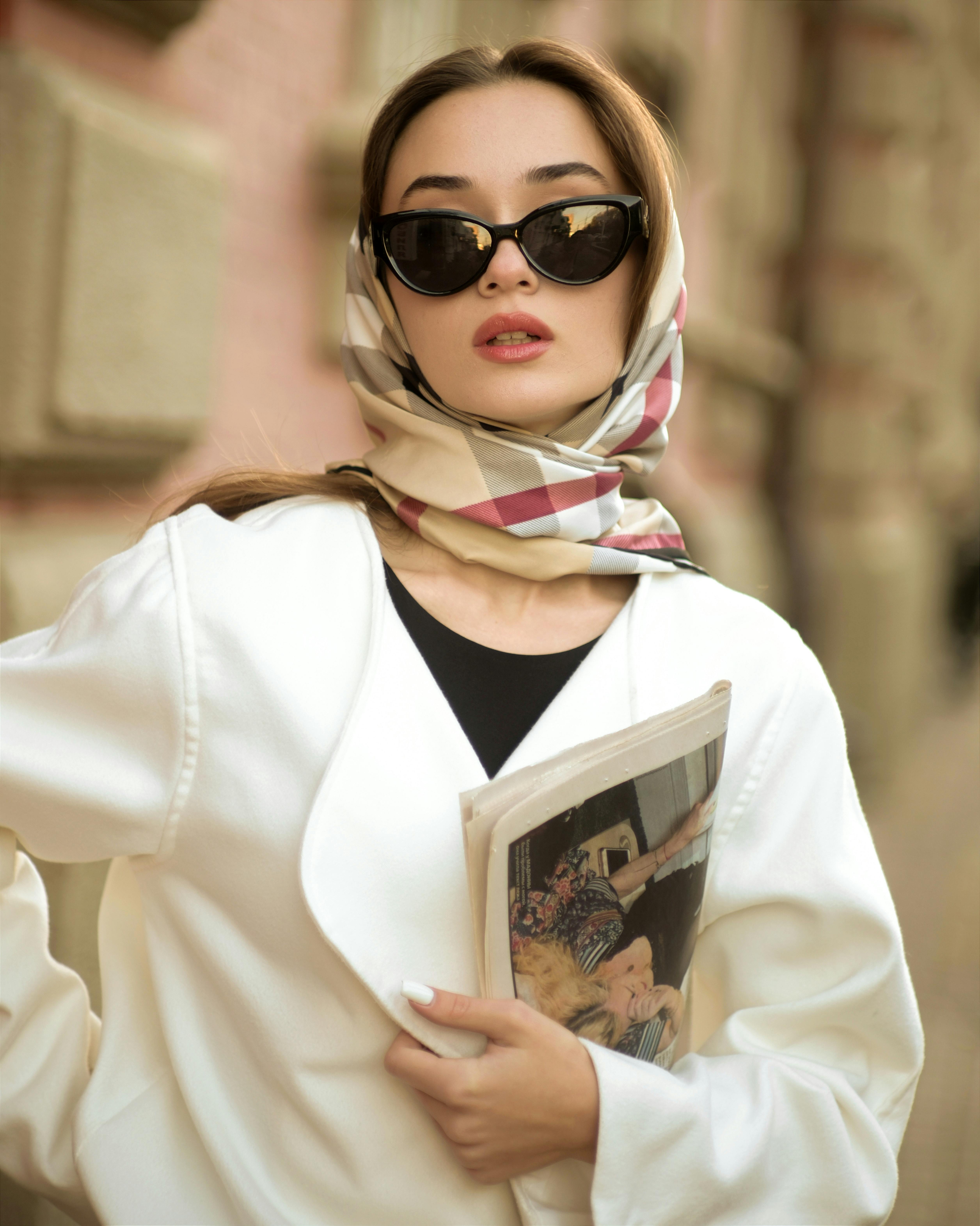 Woman in Sunglasses and a Headscarf Holding a Newspaper Free Stock Photo