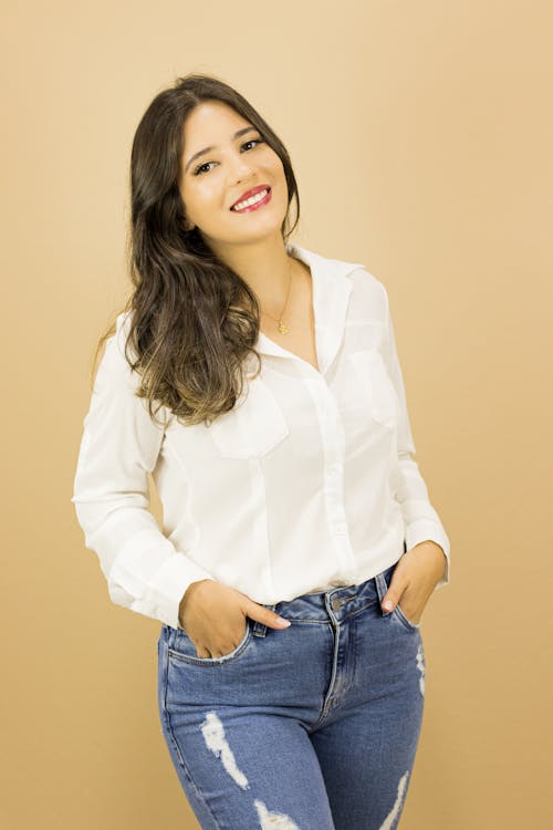 Studio Shot of Smiling Brunette in Blouse and Jeans