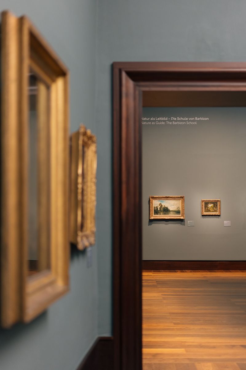 Interior view of an art exhibition in Hamburg, showcasing classical framed paintings.
