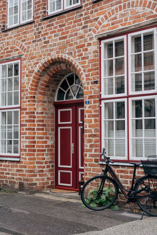 Free Red brick facade with a bicycle outside a traditional house in Lübeck, Germany. Stock Photo