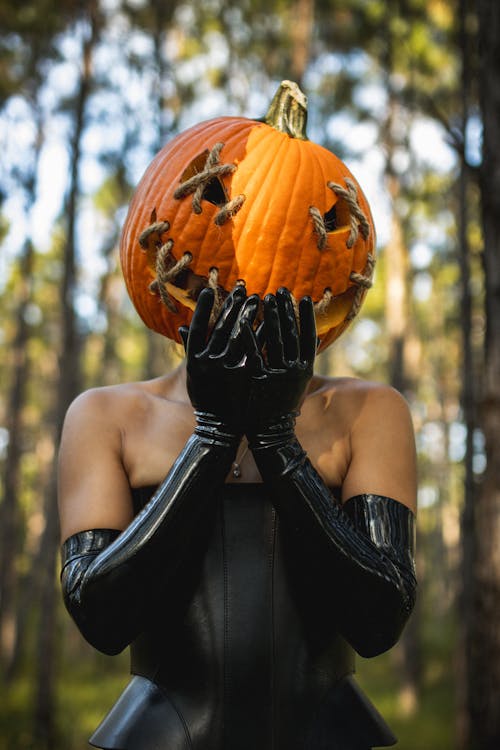 Woman Holding a Pumpkin in front of her Face 