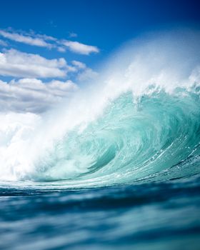 Captivating view of an ocean wave curling under a clear blue sky.