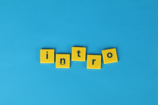 Yellow letter tiles spell 'intro' on a vibrant blue background, ideal for creative projects.