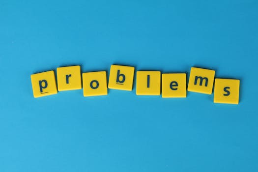 Yellow letter tiles spelling 'problems' arranged on a vibrant blue background, creating a textual concept image.