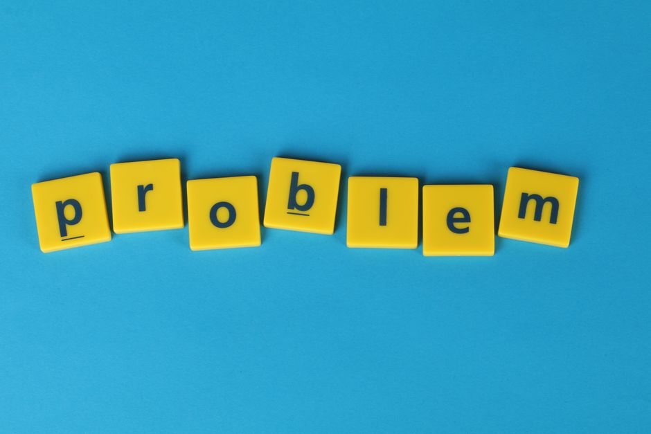 Yellow Scrabble tiles spelling 'problem' on a blue background, symbolizing challenge.
