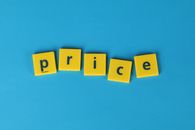 Yellow letter tiles spell the word 'price' against a vibrant blue backdrop, ideal for business concepts.