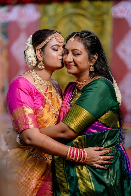 Smiling Mother and Daughter Hugging in Traditional Clothing 