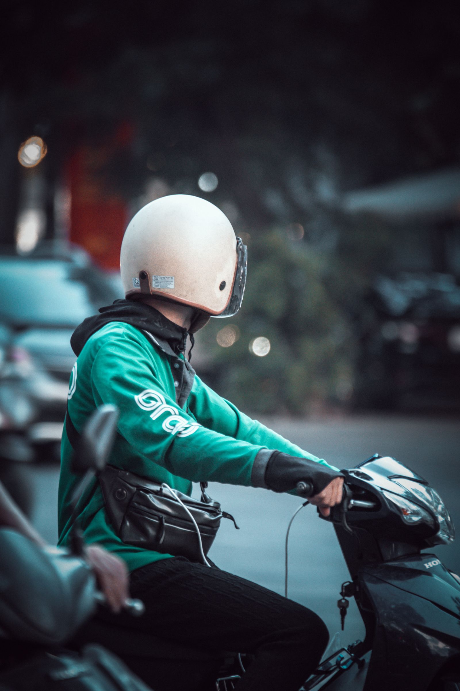 Homme casqué au guidon d'un scooter en ville