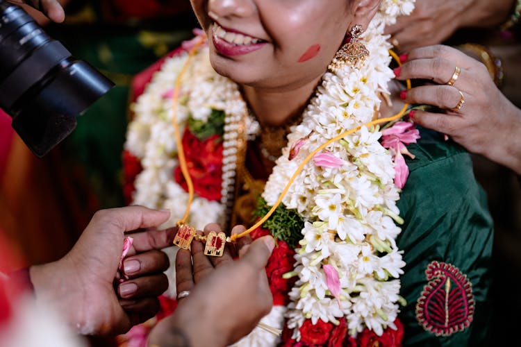 A Smiling Person With A Garland