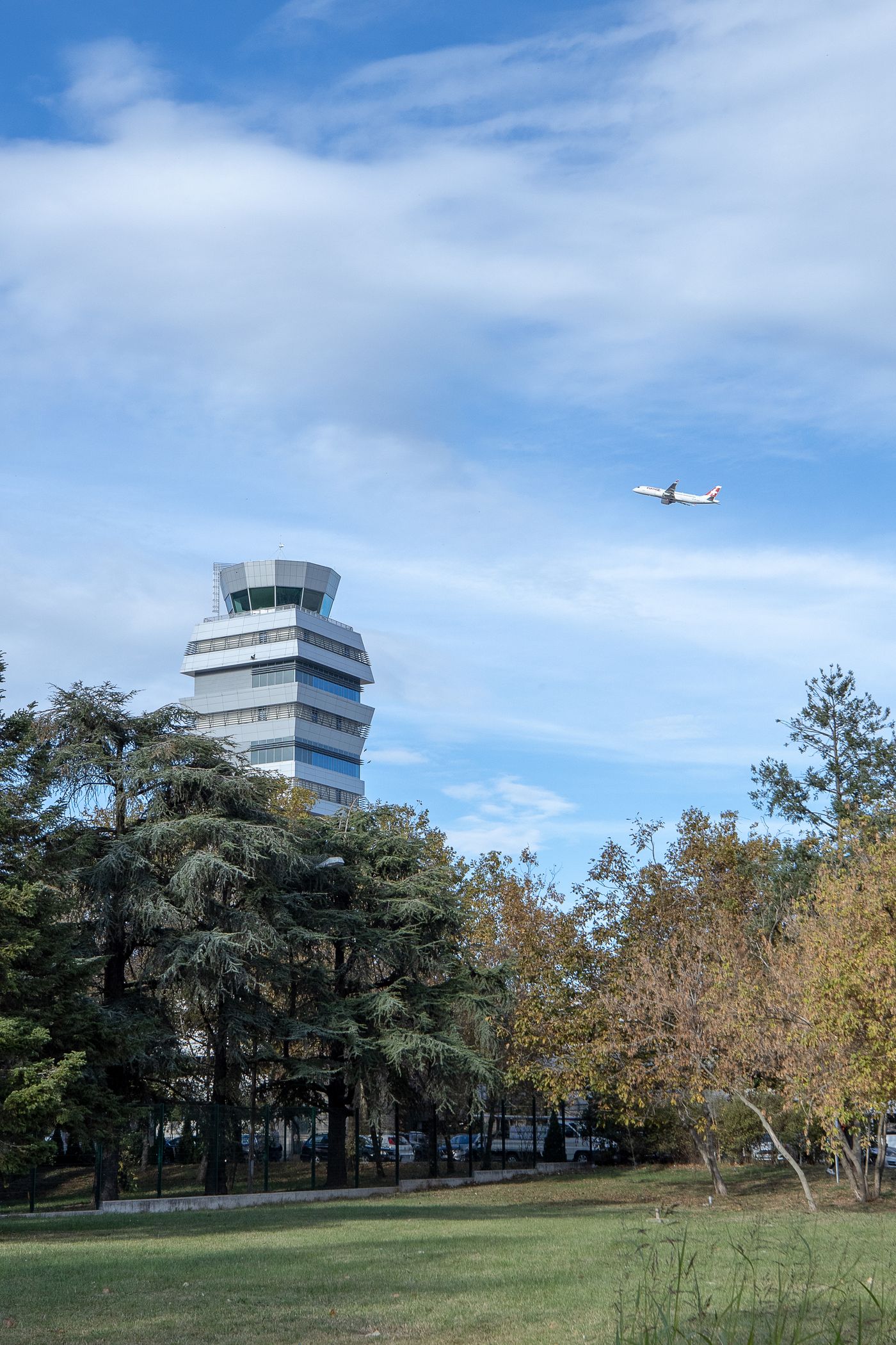 Airplane soaring past Istanbul airport control tower in clear blue sky