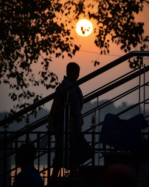 Silhouette of a Person Walking up the Stairs at Sunset