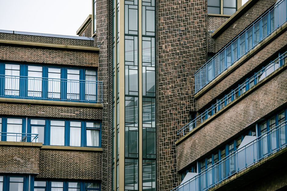 Close-up of a modern residential and commercial brick-and-glass mixed-use building facade in the UK