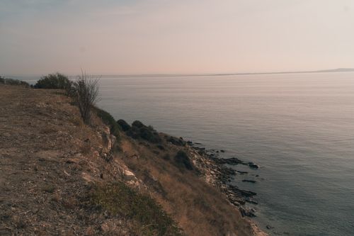 Free A calm and expansive ocean view from a rocky cliff on a clear day, capturing the tranquility of nature. Stock Photo