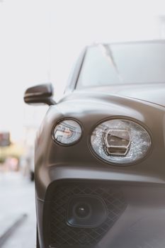 Close-up of a stylish black SUV's headlights and grille, showcasing modern automotive design.