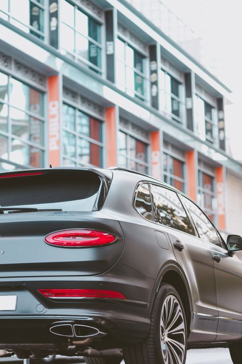 Free Rear view of a luxury SUV in Dubai's urban landscape, showcasing elegance and wealth. Stock Photo