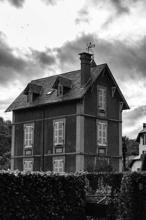 Free A traditional multi-story house with classic design in a black and white setting. Stock Photo
