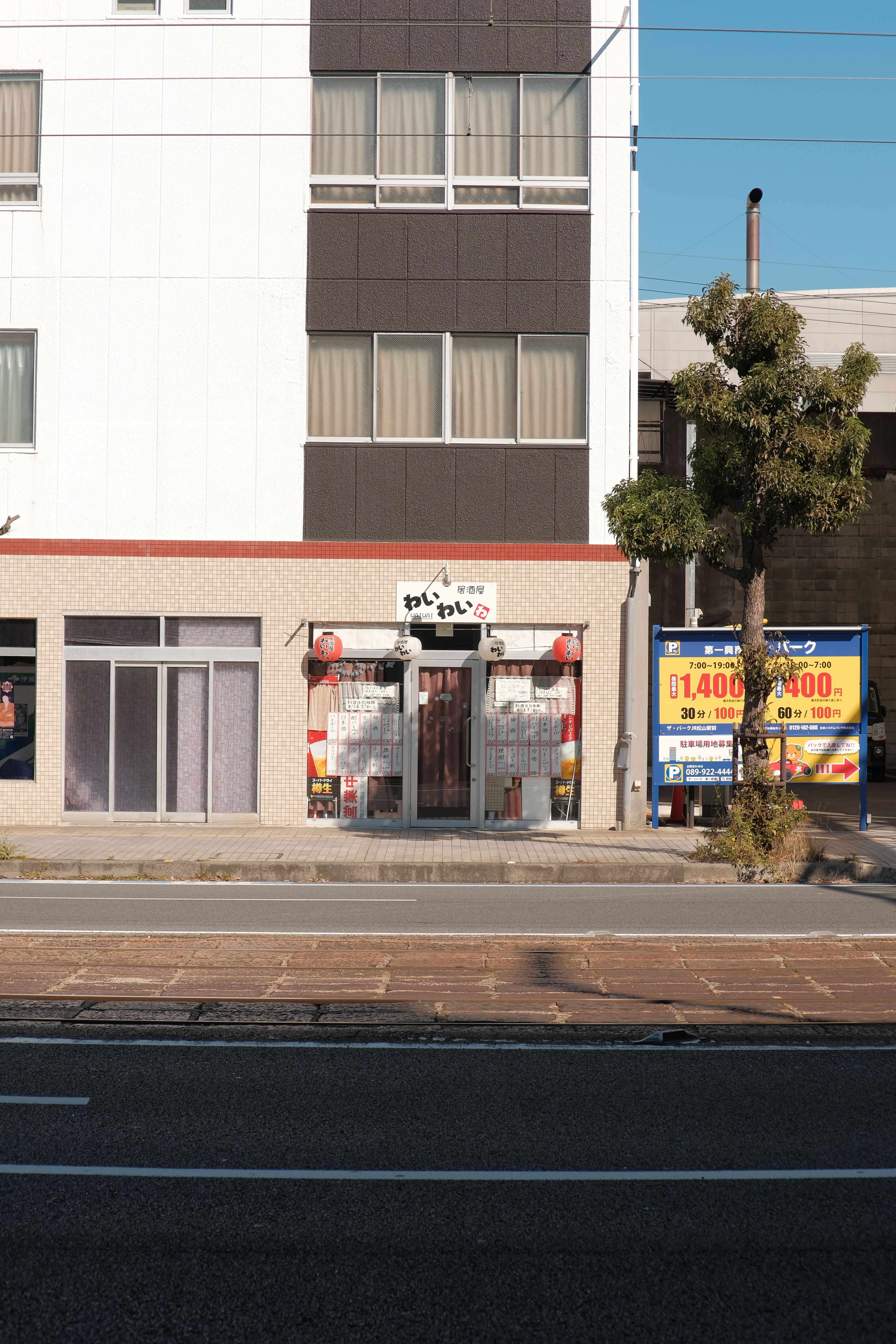 Street view of a building facade with a traditional shop and sidewalk in an urban setting.