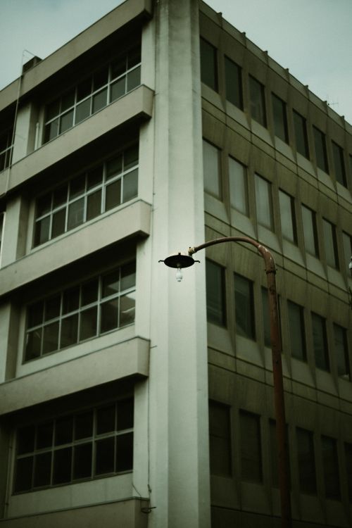 Free A city building with a streetlamp in a moody, urban setting. Stock Photo