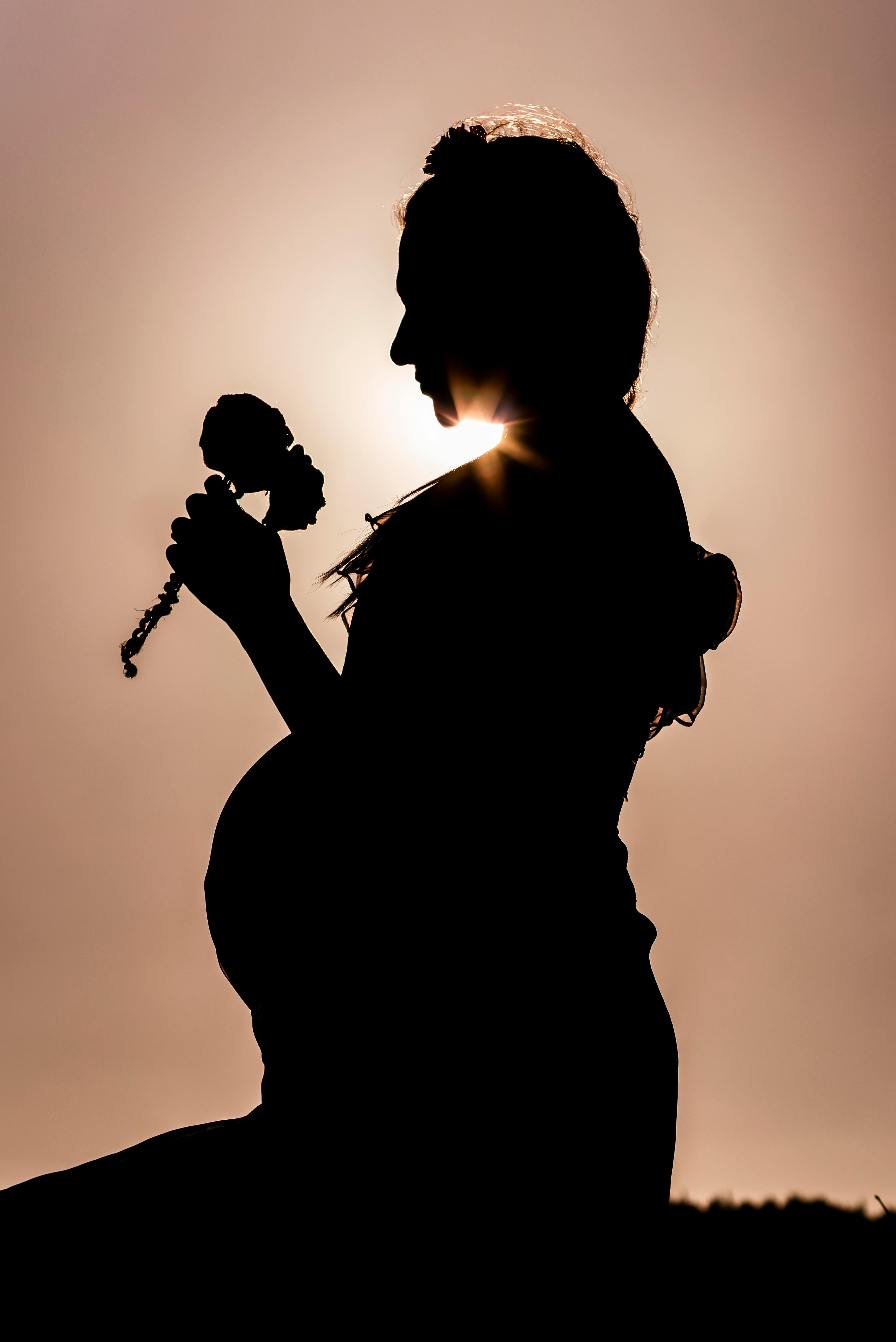 silhouette of woman holding microphone during sunset