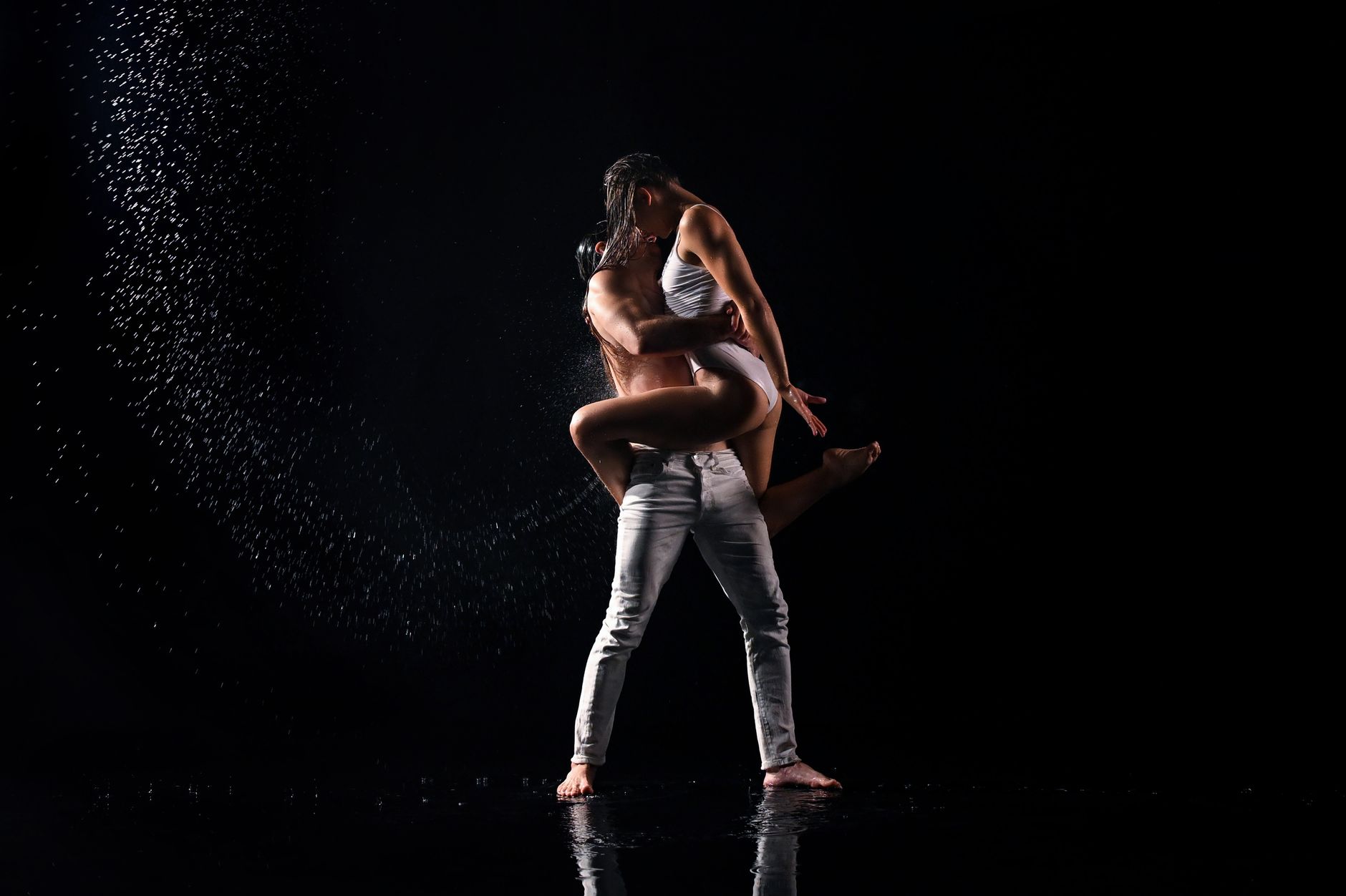 A captivating dance performance by a couple on a wet floor emphasizing movement and emotional connection.