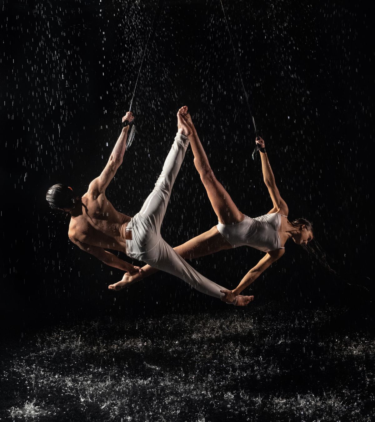 Dancing Ropers Woman and Man Dancing under Splashing Water while Suspended on Ropes ...