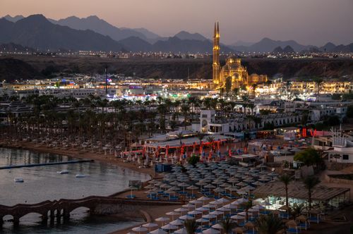 Free A stunning evening view of the illuminated resort area of Sharm El-Sheikh, Egypt, featuring a lit mosque and surrounding mountains. Stock Photo