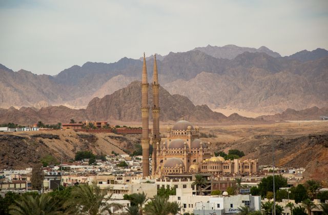A grand mosque with tall minarets in Sharm El Sheikh set against desert mountains. — arriving in Sharm El Sheikh