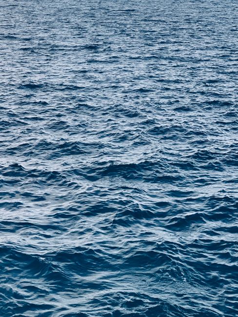 A serene seascape with wavy textures on the deep blue ocean surface.