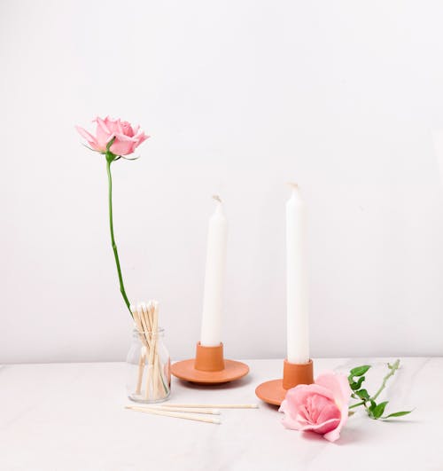 Pink Rose Flowers Next to Candles and Matches