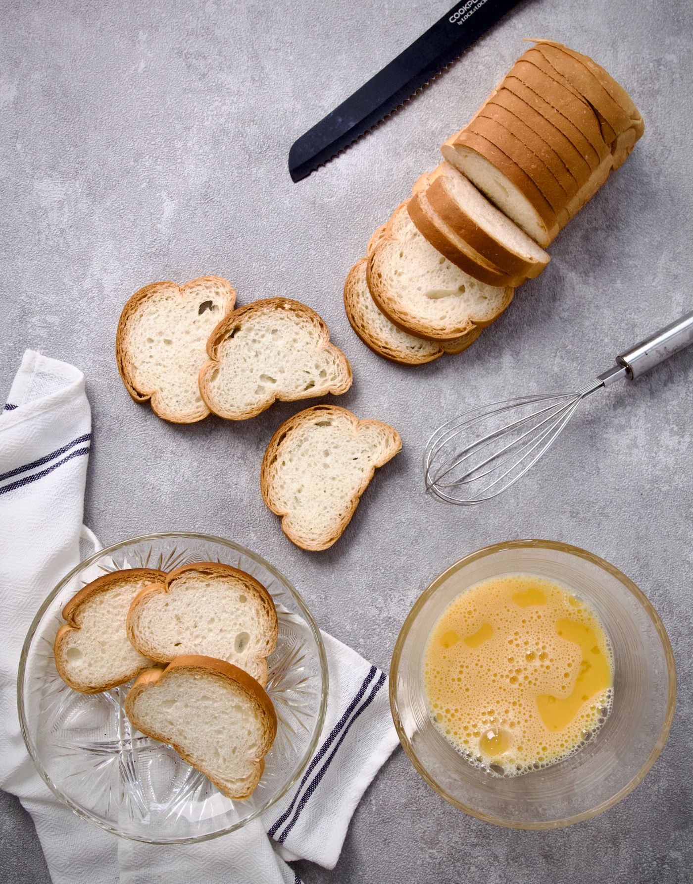 Sliced bread beside a bowl of beaten egg mixture ready for French toast