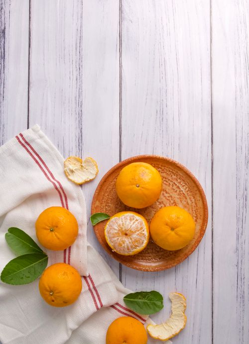 Free Top view of fresh oranges and peels on a wooden table, vibrant still life. Stock Photo