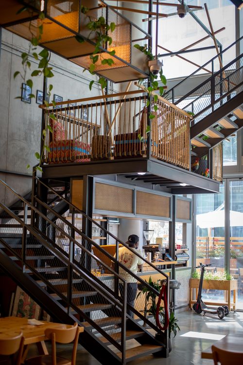Free Modern cafe interior showcasing loft-style design and indoor greenery. Stock Photo