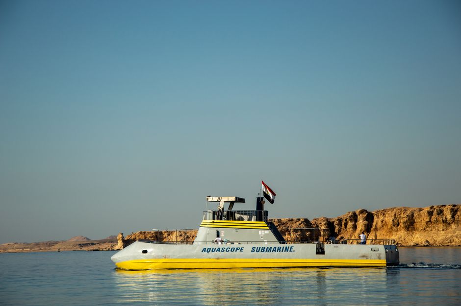 Aquascope submarine navigating the clear waters of the Red Sea with Egyptian coastline view.