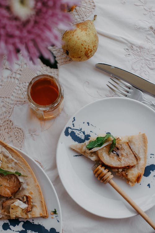 Free Still Life with a Slice of Pear Pizza and Honey Stock Photo